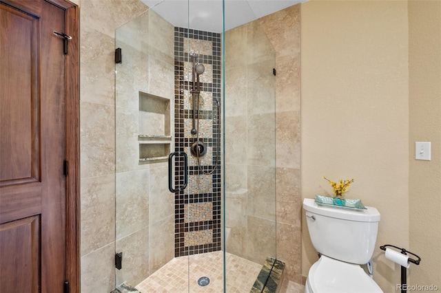 bathroom featuring a shower stall and toilet
