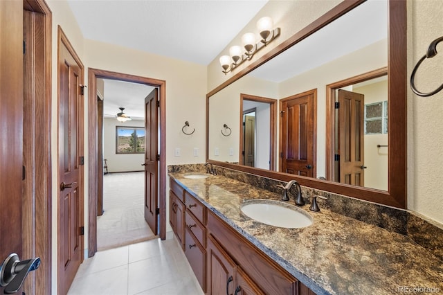 bathroom with a ceiling fan, tile patterned floors, double vanity, and a sink