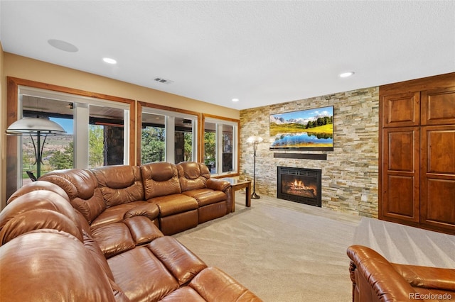 living room featuring a fireplace, plenty of natural light, carpet floors, and visible vents