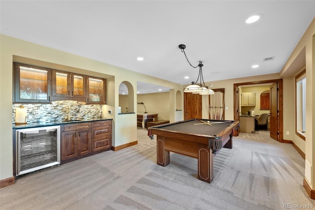 rec room featuring a sink, wet bar, visible vents, arched walkways, and beverage cooler