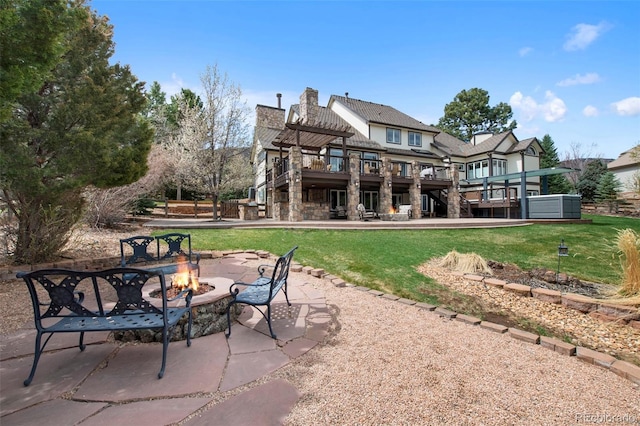 back of property with stairs, a deck, a fire pit, a patio, and a lawn