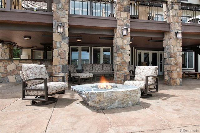 view of patio with a balcony, french doors, and a fire pit