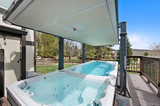 wooden terrace featuring a hot tub