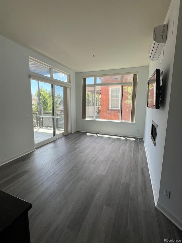 336 E 1st Ave Unit 200, Denver, CO 80203 - unfurnished living room with a wall mounted AC, dark wood-style floors, and a glass covered fireplace