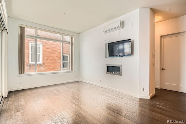 336 E 1st Ave Unit 200, Denver, CO 80203 - unfurnished living room with a wall mounted AC, a fireplace, and hardwood / wood-style floors