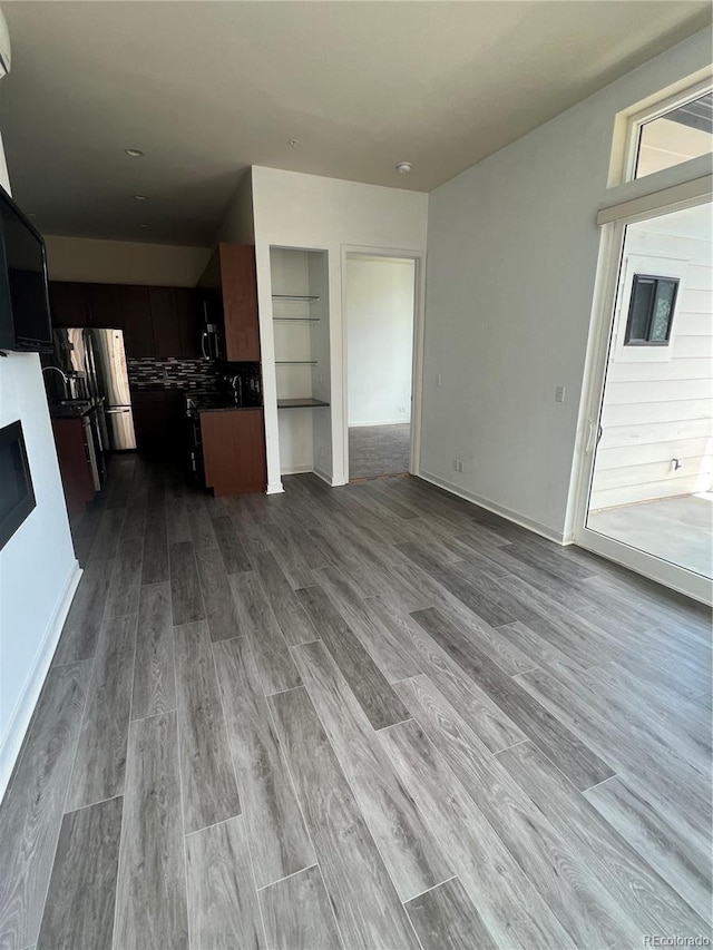 336 E 1st Ave Unit 200, Denver, CO 80203 - kitchen featuring open floor plan, dark wood-style floors, dark countertops, a fireplace, and stainless steel refrigerator with ice dispenser