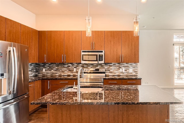 336 E 1st Ave Unit 200, Denver, CO 80203 - kitchen featuring appliances with stainless steel finishes, brown cabinetry, dark stone countertops, and recessed lighting