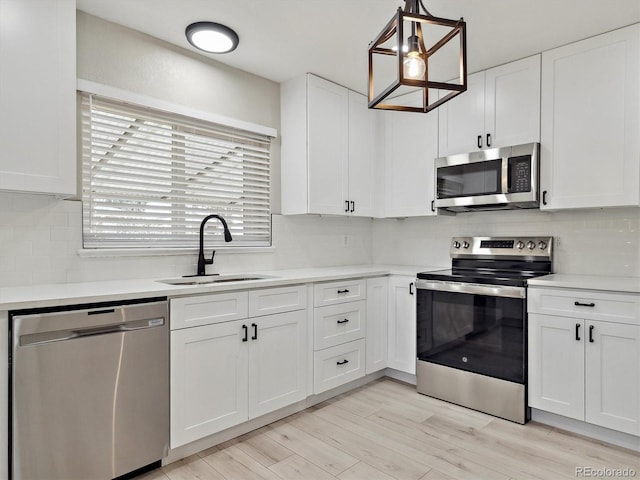 kitchen featuring light countertops, white cabinets, tasteful backsplash, a sink, and stainless steel appliances