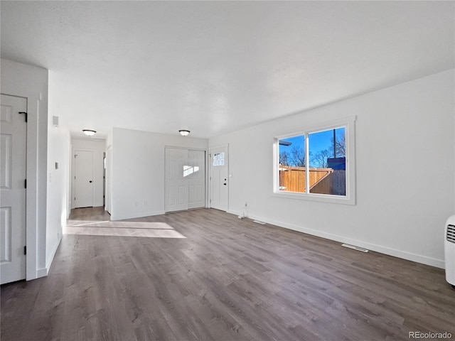 unfurnished living room with dark hardwood / wood-style flooring