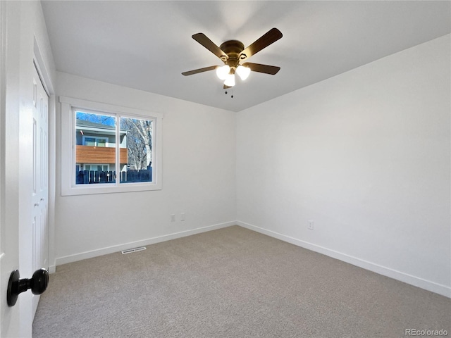 empty room with ceiling fan and light colored carpet