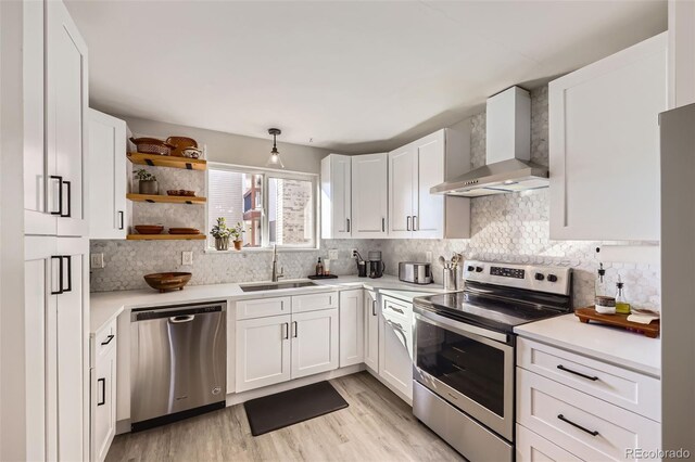 8450 Decatur St Unit 97, Westminster, CO 80031 - kitchen featuring stainless steel appliances, wall chimney range hood, white cabinets, and light countertops