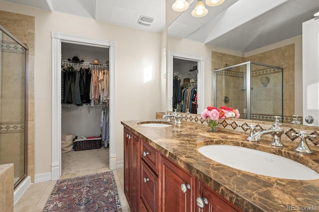 bathroom featuring vanity, a shower with door, tile patterned flooring, and vaulted ceiling