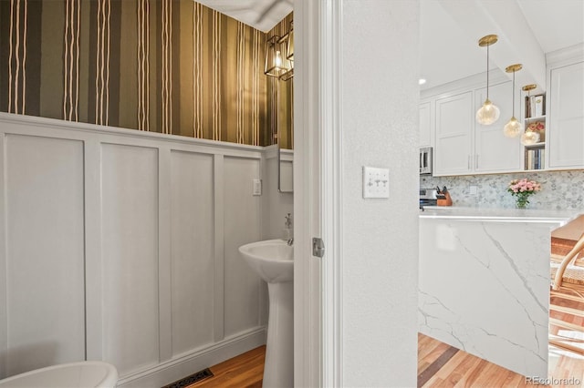 2801 W 23rd Ave, Denver, CO 80211 - bathroom with a decorative wall, visible vents, and wood finished floors