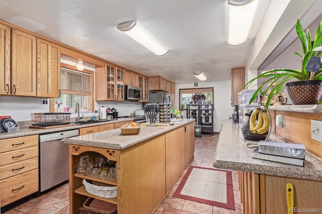 9400 W Burgundy Ave, Littleton, CO 80123 - kitchen with appliances with stainless steel finishes, a kitchen island, healthy amount of natural light, and glass insert cabinets