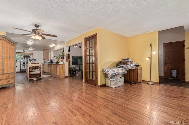 9400 W Burgundy Ave, Littleton, CO 80123 - living room featuring hardwood / wood-style floors, a textured ceiling, and a ceiling fan