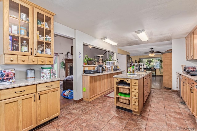 9400 W Burgundy Ave, Littleton, CO 80123 - kitchen featuring ceiling fan, glass insert cabinets, open shelves, light brown cabinetry, and a center island