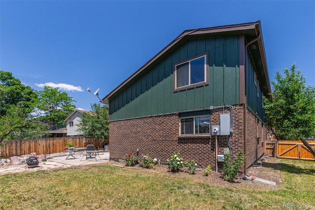 9400 W Burgundy Ave, Littleton, CO 80123 - view of side of property with board and batten siding, a patio area, a fenced backyard, and brick siding