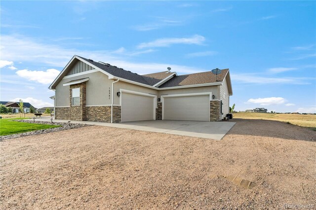 view of front of home featuring a garage, stone siding, concrete driveway, and stucco siding