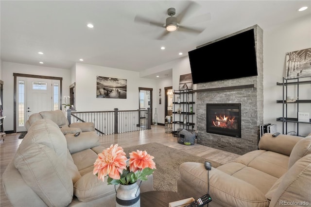 living area with a fireplace, wood finished floors, a wealth of natural light, and recessed lighting