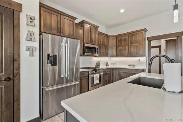 kitchen featuring decorative light fixtures, tasteful backsplash, recessed lighting, appliances with stainless steel finishes, and a sink