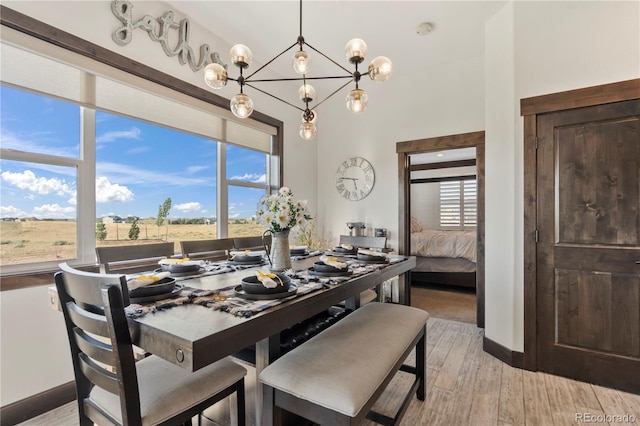 dining area featuring a notable chandelier, baseboards, a wealth of natural light, and light wood-style floors