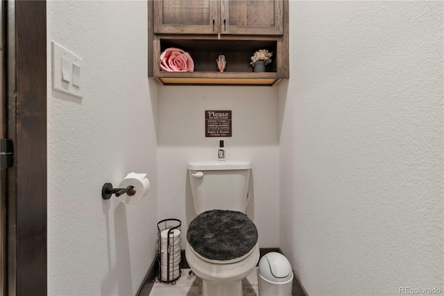 bathroom with a textured wall and toilet