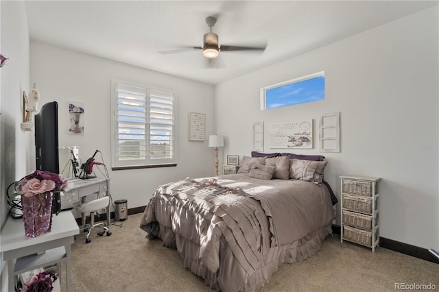 carpeted bedroom with a ceiling fan, multiple windows, and baseboards