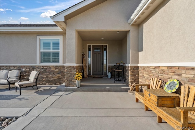 view of exterior entry featuring stucco siding and stone siding