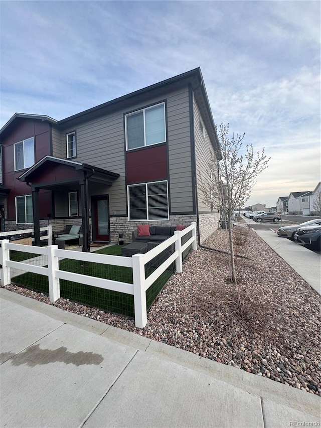 1353 Reynolds St Unit 5A, Fort Lupton, CO 80621 - view of front of home featuring stone siding and a fenced front yard