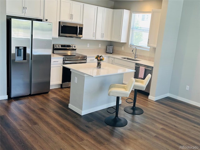 1353 Reynolds St Unit 5A, Fort Lupton, CO 80621 - kitchen with appliances with stainless steel finishes, dark wood-style floors, a kitchen breakfast bar, and white cabinets
