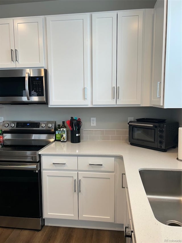 1353 Reynolds St Unit 5A, Fort Lupton, CO 80621 - kitchen with stainless steel appliances, white cabinetry, and light countertops
