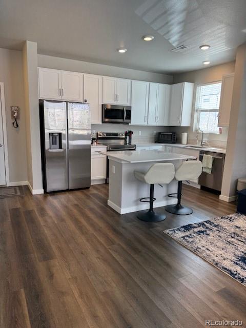 1353 Reynolds St Unit 5A, Fort Lupton, CO 80621 - kitchen featuring stainless steel appliances, light countertops, recessed lighting, white cabinetry, and a kitchen island