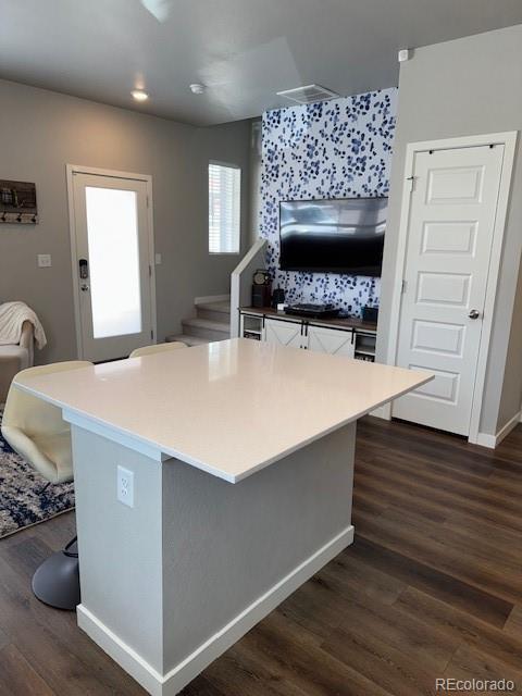 1353 Reynolds St Unit 5A, Fort Lupton, CO 80621 - kitchen with dark wood-style floors, a kitchen bar, a center island, light countertops, and recessed lighting