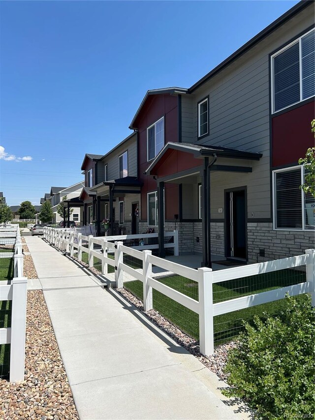 1353 Reynolds St Unit 5A, Fort Lupton, CO 80621 - view of front of property with a fenced front yard and covered porch