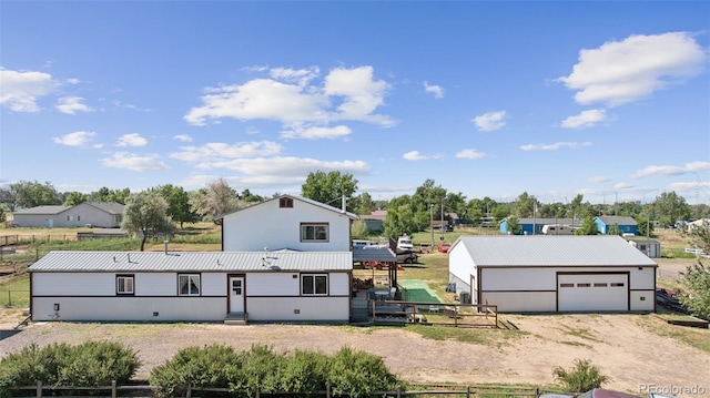 15528 Nancy Ave, Fort Lupton, CO 80621 - view of front of house featuring a metal roof, driveway, an outdoor structure, and a detached garage