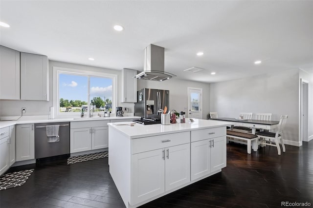 15528 Nancy Ave, Fort Lupton, CO 80621 - kitchen with appliances with stainless steel finishes, island exhaust hood, dark wood-style floors, a kitchen island, and recessed lighting