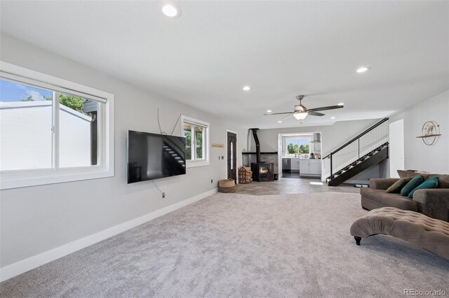 15528 Nancy Ave, Fort Lupton, CO 80621 - carpeted living area featuring stairway, recessed lighting, healthy amount of natural light, a ceiling fan, and a wood stove
