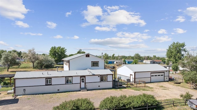 15528 Nancy Ave, Fort Lupton, CO 80621 - view of front of home with dirt driveway, a metal roof, a detached garage, and an outdoor structure