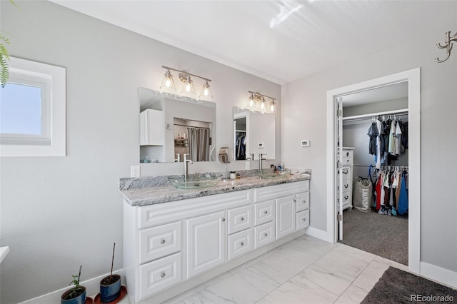 15528 Nancy Ave, Fort Lupton, CO 80621 - bathroom with double vanity, a walk in closet, and marble look tile flooring