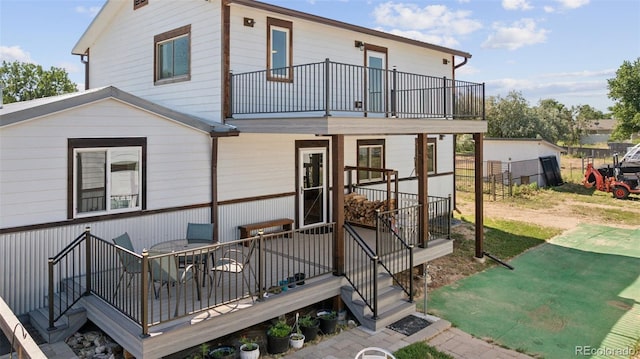 15528 Nancy Ave, Fort Lupton, CO 80621 - rear view of house with a balcony, a yard, and outdoor dining space