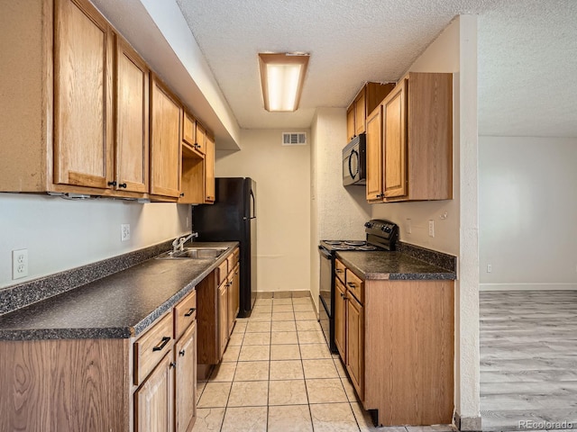 kitchen featuring sink, a textured ceiling, and black appliances