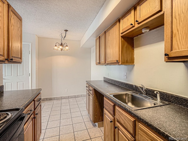 kitchen with pendant lighting, sink, light tile patterned floors, black range, and a textured ceiling