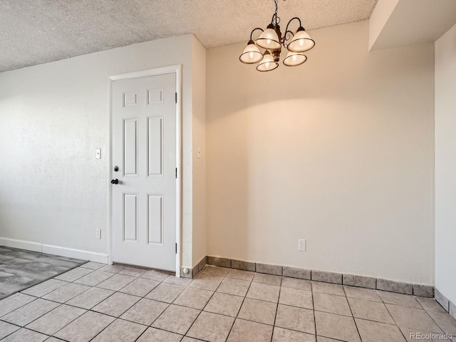 unfurnished dining area featuring light tile patterned floors, a textured ceiling, and an inviting chandelier