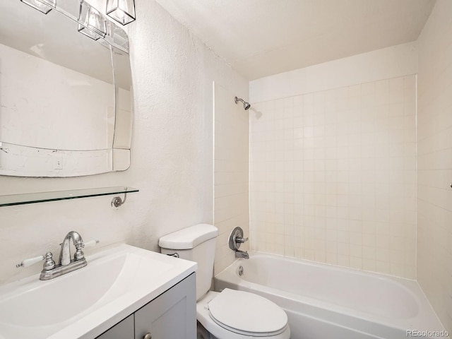 full bathroom with tiled shower / bath, vanity, and toilet