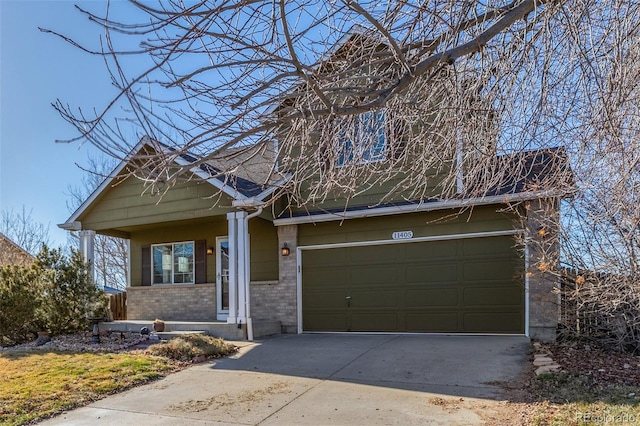 view of front of property featuring an attached garage, concrete driveway, and brick siding