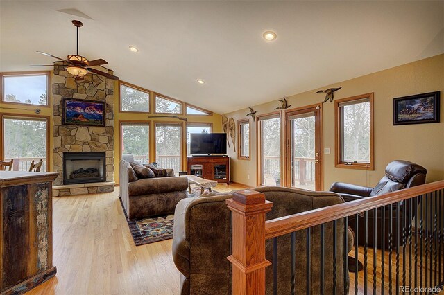 199 Elk Horn Ct, Bailey, CO 80421 - living room with a ceiling fan, light wood-style flooring, vaulted ceiling, plenty of natural light, and a fireplace