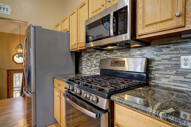 199 Elk Horn Ct, Bailey, CO 80421 - kitchen featuring appliances with stainless steel finishes, tasteful backsplash, light brown cabinets, and dark stone countertops