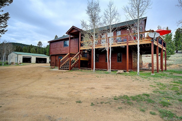 199 Elk Horn Ct, Bailey, CO 80421 - back of property featuring a garage, a deck, stairs, and an outdoor structure