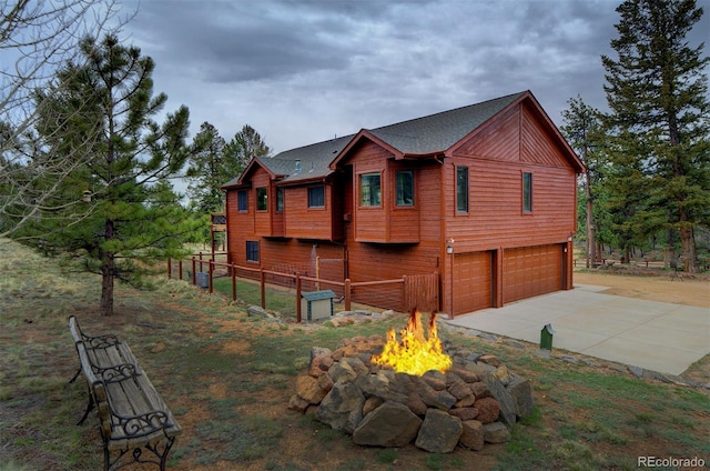199 Elk Horn Ct, Bailey, CO 80421 - view of side of property featuring a garage, a fire pit, and driveway