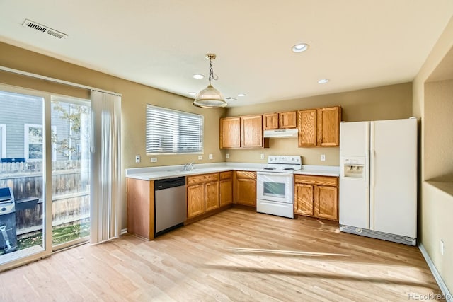 kitchen featuring light hardwood / wood-style flooring, pendant lighting, and white appliances